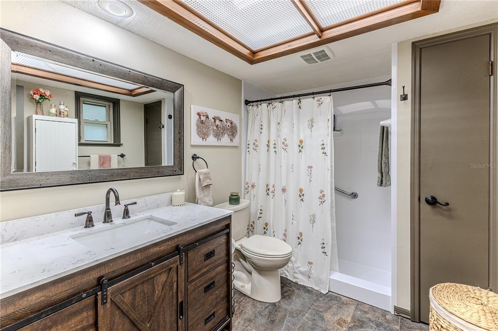 8480 Colma Street Spring Hill, FL 34606 - Photo 36 of 70 a spacious bathroom with a granite countertop sink a toilet a shower and a mirror