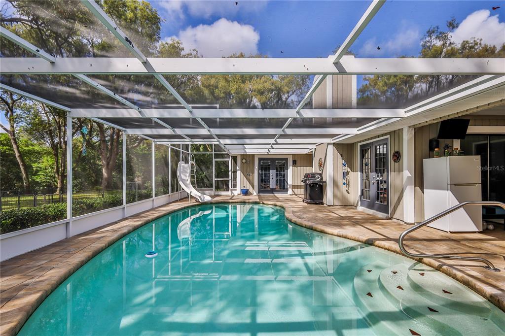 8480 Colma Street Spring Hill, FL 34606 - Photo 50 of 70 a view of a backyard with table and chairs under an umbrella