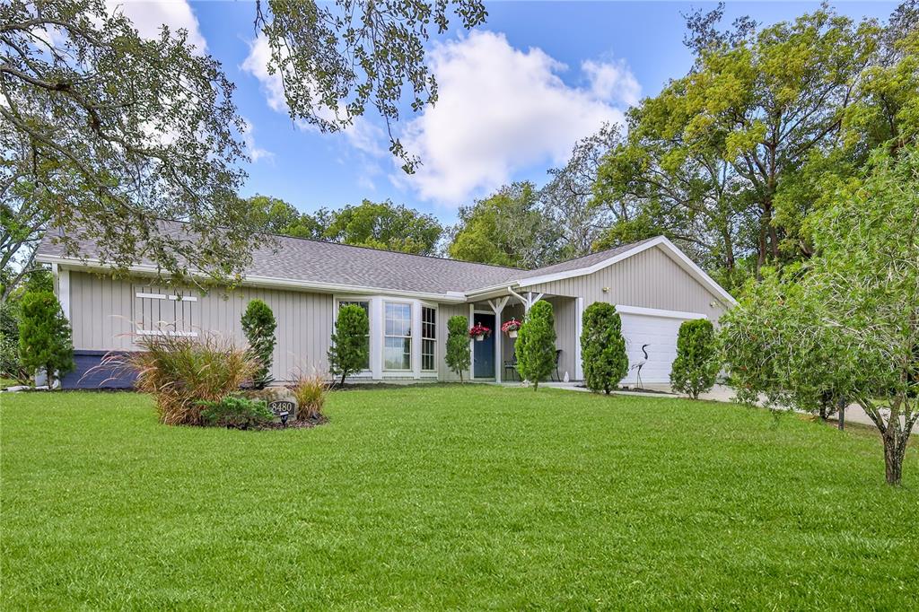 8480 Colma Street Spring Hill, FL 34606 - Photo 5 of 70 a front view of house with a garden and trees