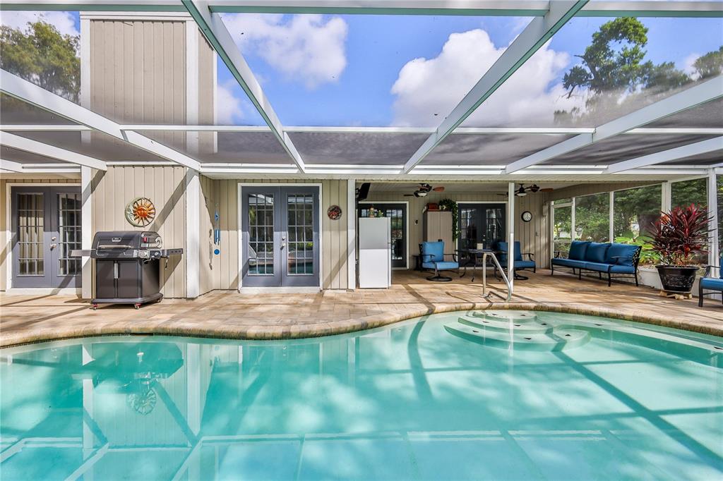 8480 Colma Street Spring Hill, FL 34606 - Photo 51 of 70 a view of a patio with table and chairs potted plants with wooden floor