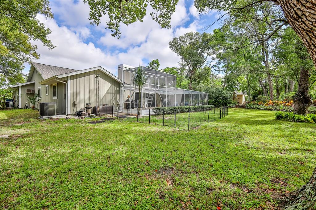 8480 Colma Street Spring Hill, FL 34606 - Photo 54 of 70 a view of a house with a big yard and large trees