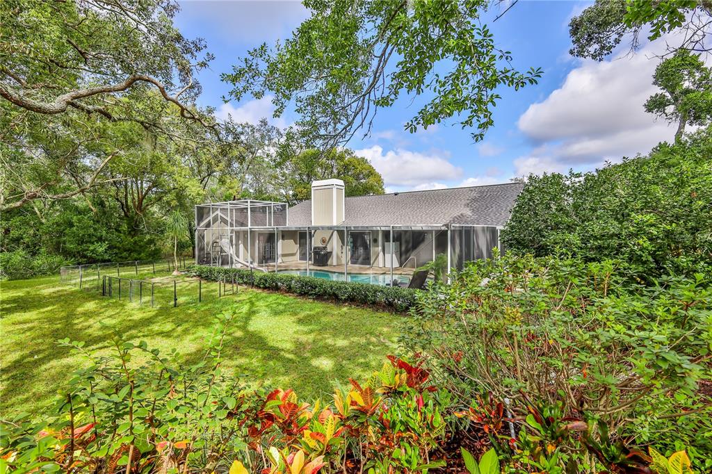 8480 Colma Street Spring Hill, FL 34606 - Photo 56 of 70 a view of a house with a big yard and large trees