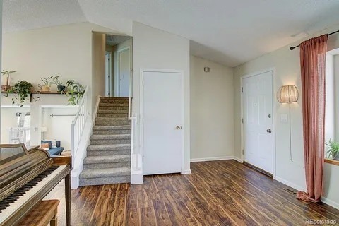 a view of a hallway with wooden floor and staircase