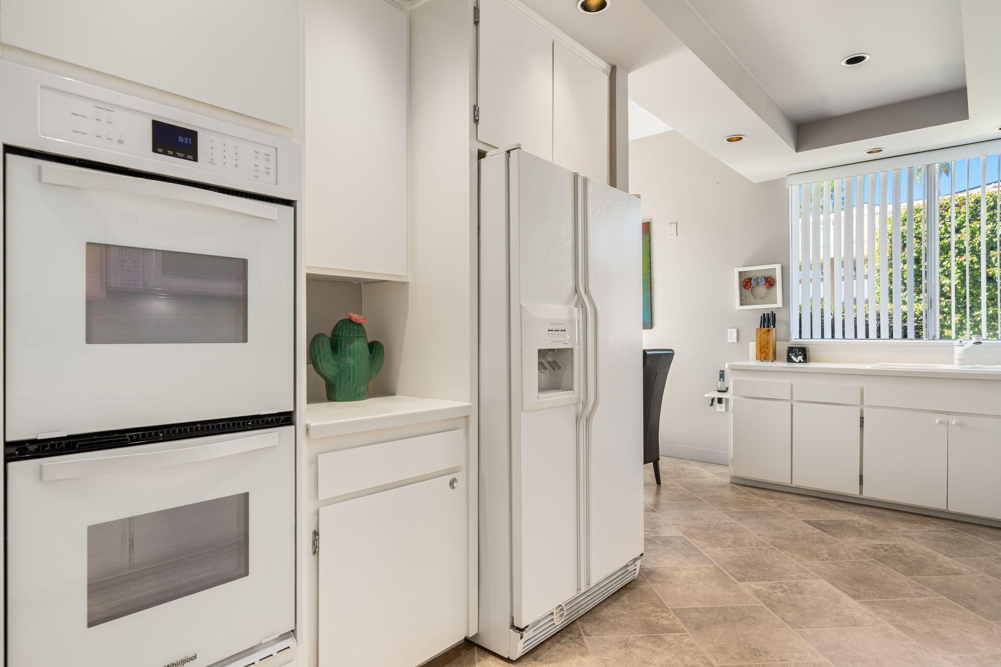 1408 Tamarisk W Street Rancho Mirage, CA 92270 - Photo 21 of 43 a kitchen with white cabinets and white appliances