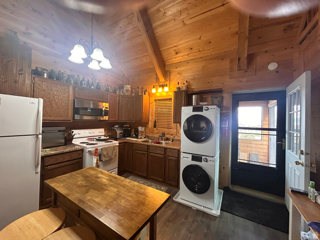19075 West Honesty Cove Duchesne, UT 84021 - Photo 7 of 44 Kitchen featuring wood-finish cabinetry, white appliances, and a wood-finish island