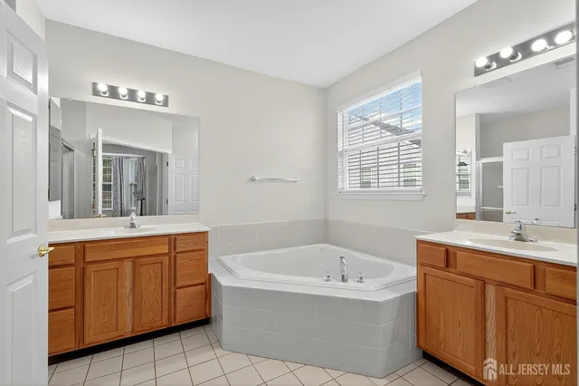 a bathroom with a tub sink and mirror