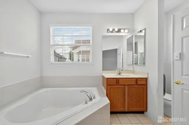 a bathroom with a tub sink and mirror
