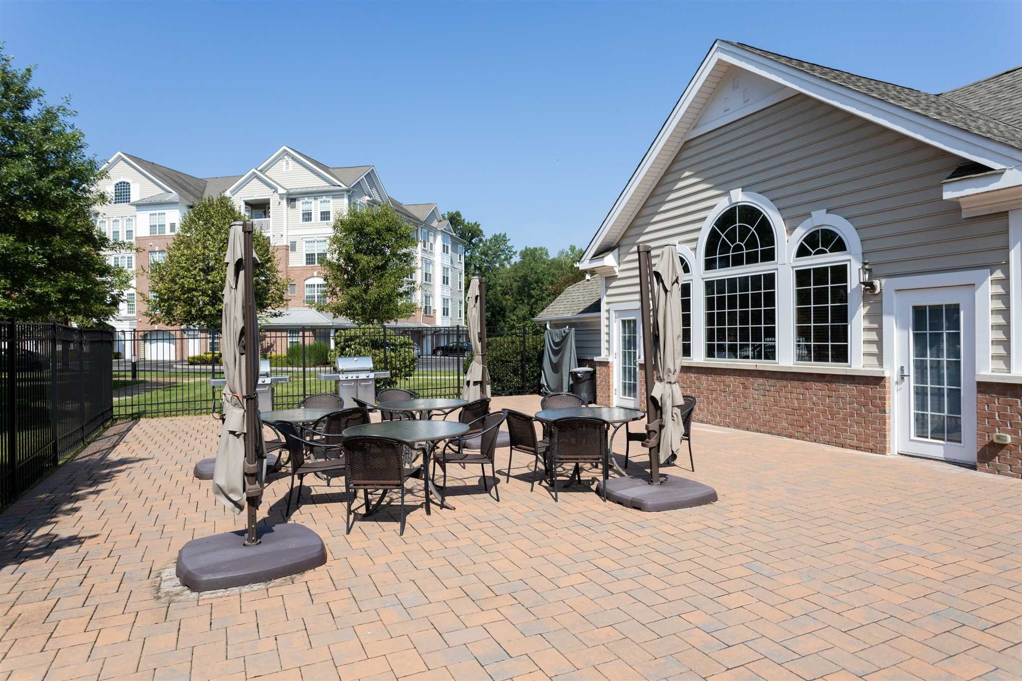 224 Regency Drive, Unit 224 Fishkill, NY 12524 - Photo 28 of 30 a view of a patio with table and chairs potted plants and a large tree