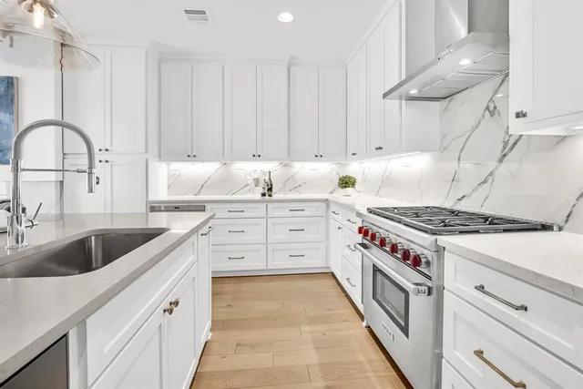 a kitchen with granite countertop a sink a stove and cabinets