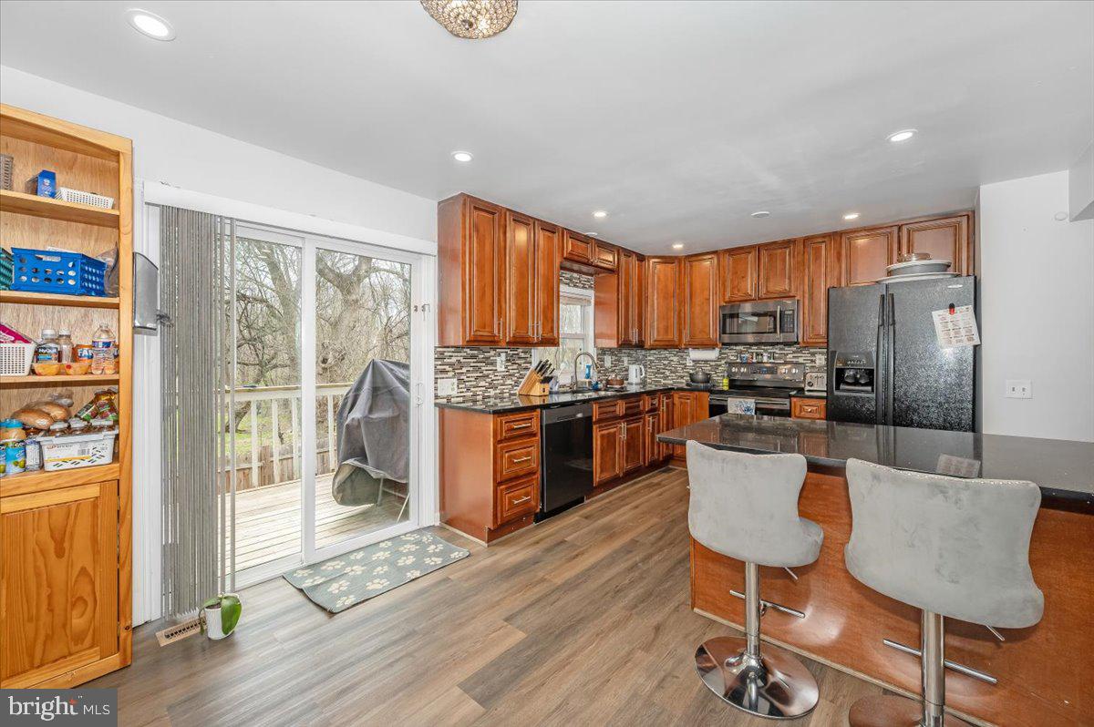 1864 Murdock Court Frederick, MD 21702 - Photo 5 of 39 a kitchen with stainless steel appliances granite countertop a refrigerator a stove top oven and a dining table with wooden floor