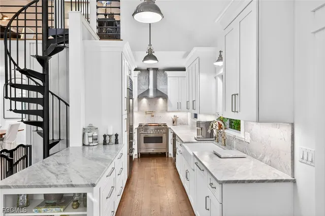 a large white kitchen with a sink and dishwasher a stove with wooden floor