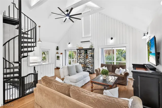 a living room with furniture a flat screen tv and a window