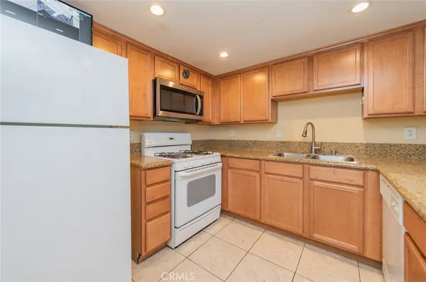 a kitchen with stainless steel appliances granite countertop a refrigerator stove a sink and a microwave