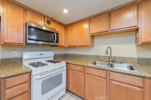 a kitchen with granite countertop cabinets stainless steel appliances and a sink