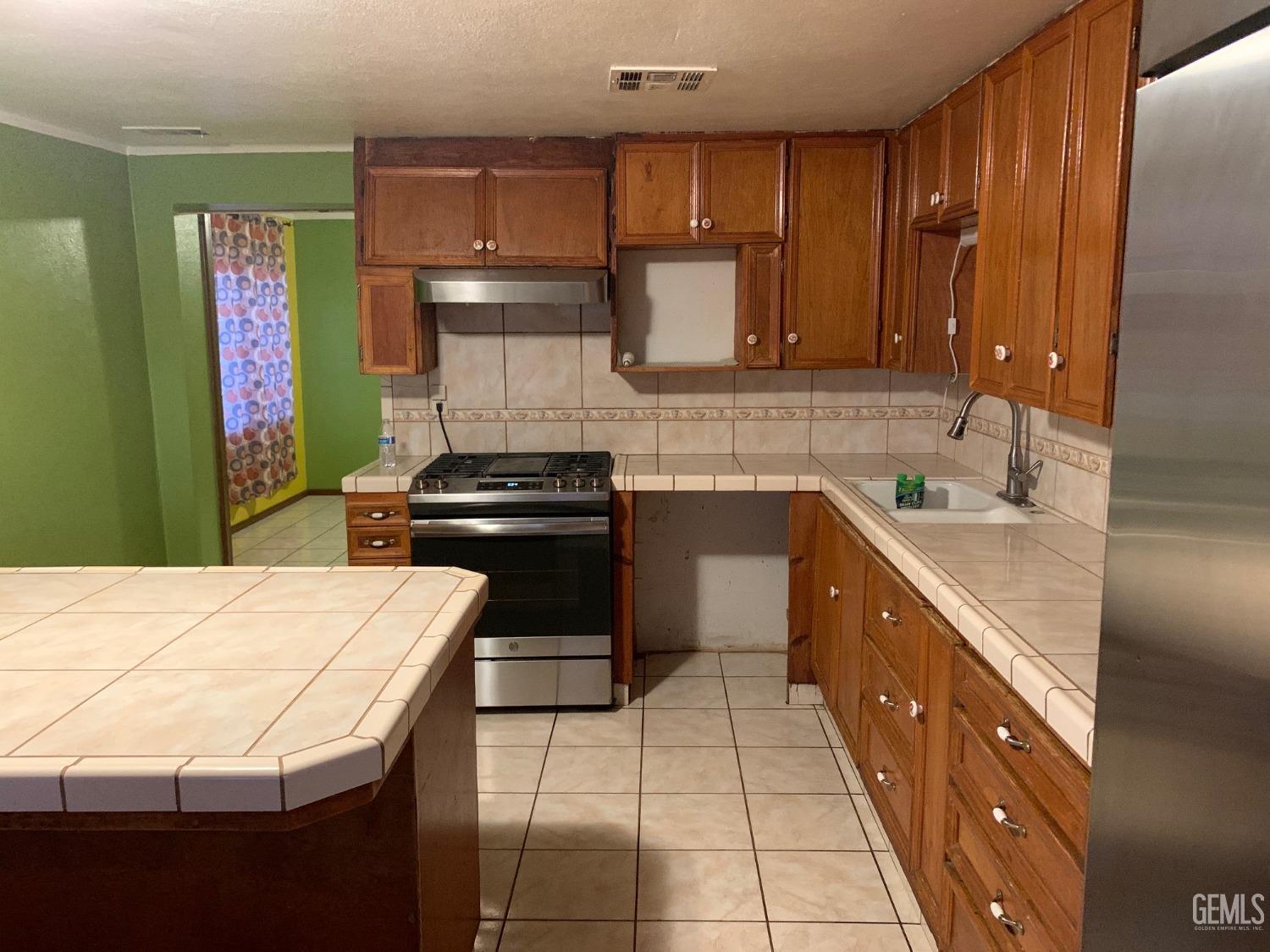Undisclosed Address Lamont, CA 93241 - Photo 4 of 10 a kitchen with a sink refrigerator and cabinets