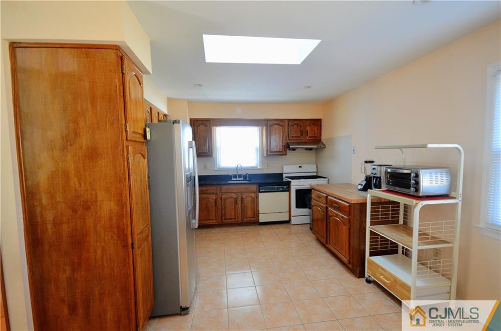 2 Ridge Road Edison, NJ 08817 - Photo 5 of 18 a large kitchen with stainless steel appliances a refrigerator and a stove top oven