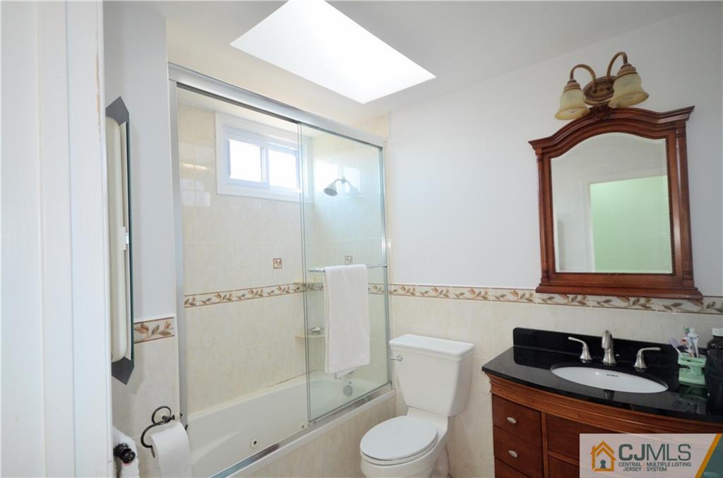 2 Ridge Road Edison, NJ 08817 - Photo 10 of 18 a bathroom with a toilet sink vanity and mirror