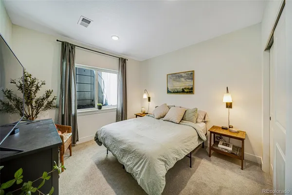 a bedroom with a large bed and a potted plant