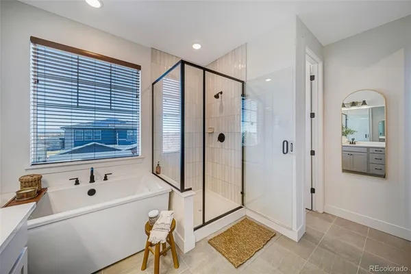 a bathroom with a tub sink shower and mirror
