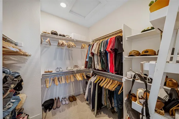 a view of walk in closet with clothes and shoes