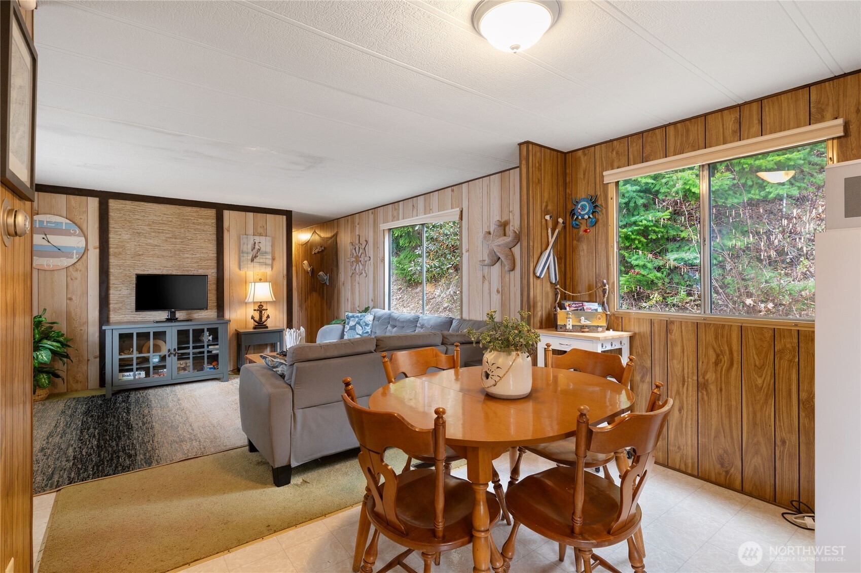 71 Bald Point Court Tahuya, WA 98588 - Photo 11 of 32 a dining room with furniture a large window and a flat screen tv