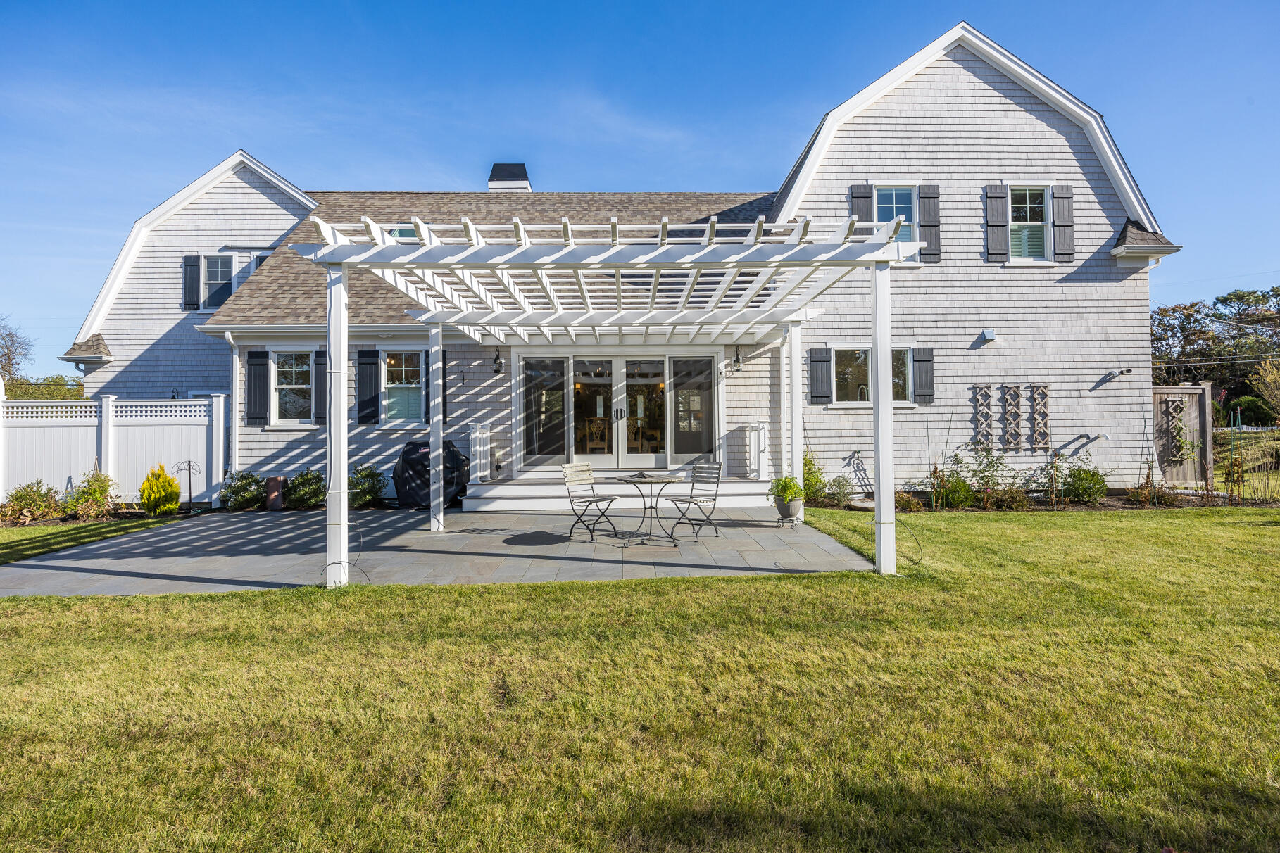 20 Cockle Cove Road South Chatham, MA 02659 - Photo 37 of 42 a view of a white house with a yard patio and couches chairs