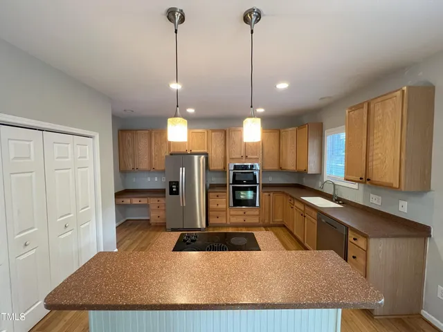a large kitchen with kitchen island a large counter space a sink and appliances