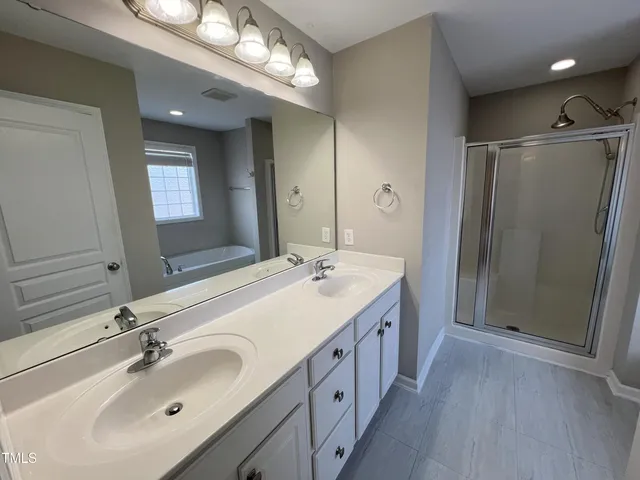 a bathroom with double vanity sink and a mirror