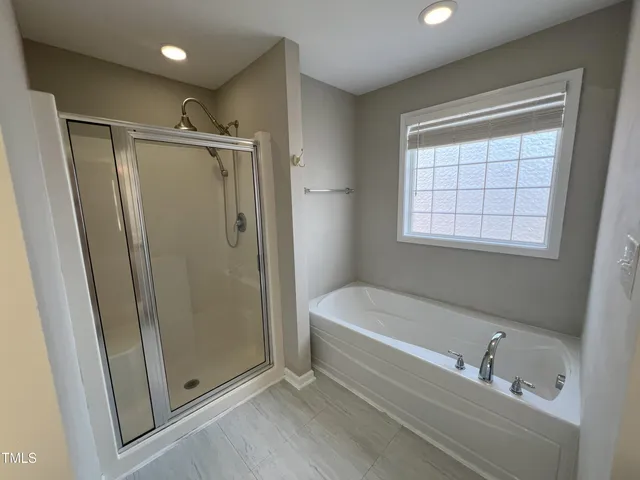 a bathroom with a tub a sink and a shower