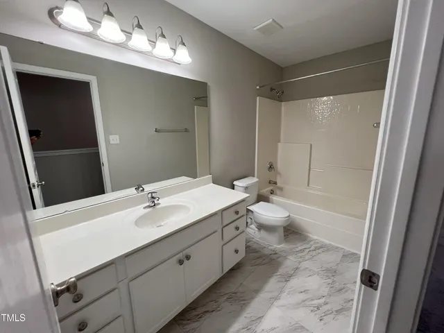 a bathroom with a double vanity sink mirror and toilet