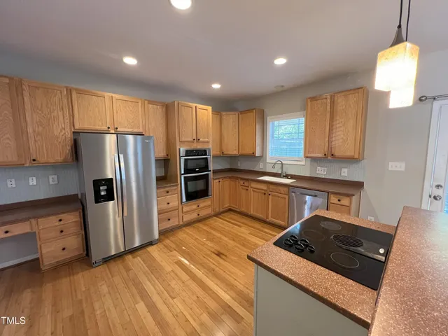 a kitchen with stainless steel appliances granite countertop a refrigerator stove and sink