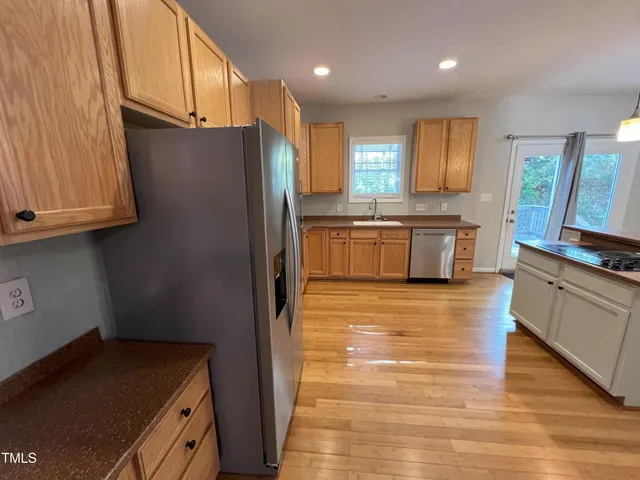a kitchen with granite countertop a refrigerator and a stove top oven