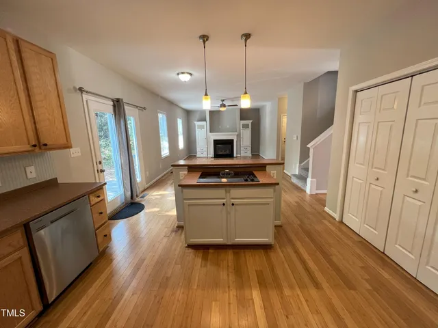 a kitchen with stainless steel appliances granite countertop a refrigerator a stove and a wooden floors