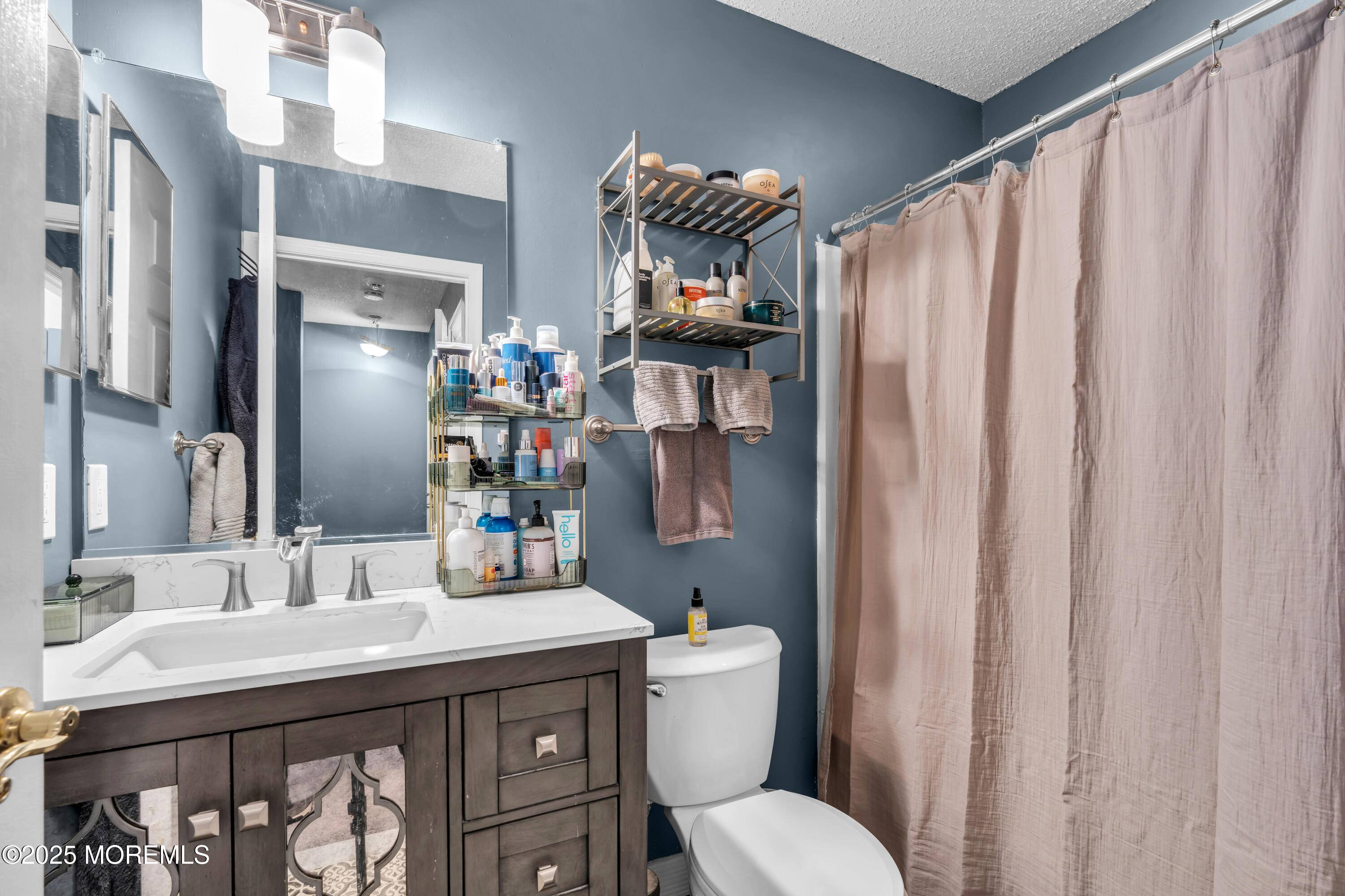 11 Madison Court Tinton Falls, NJ 07712 - Photo 16 of 24 a bathroom with a sink a toilet and shower curtain
