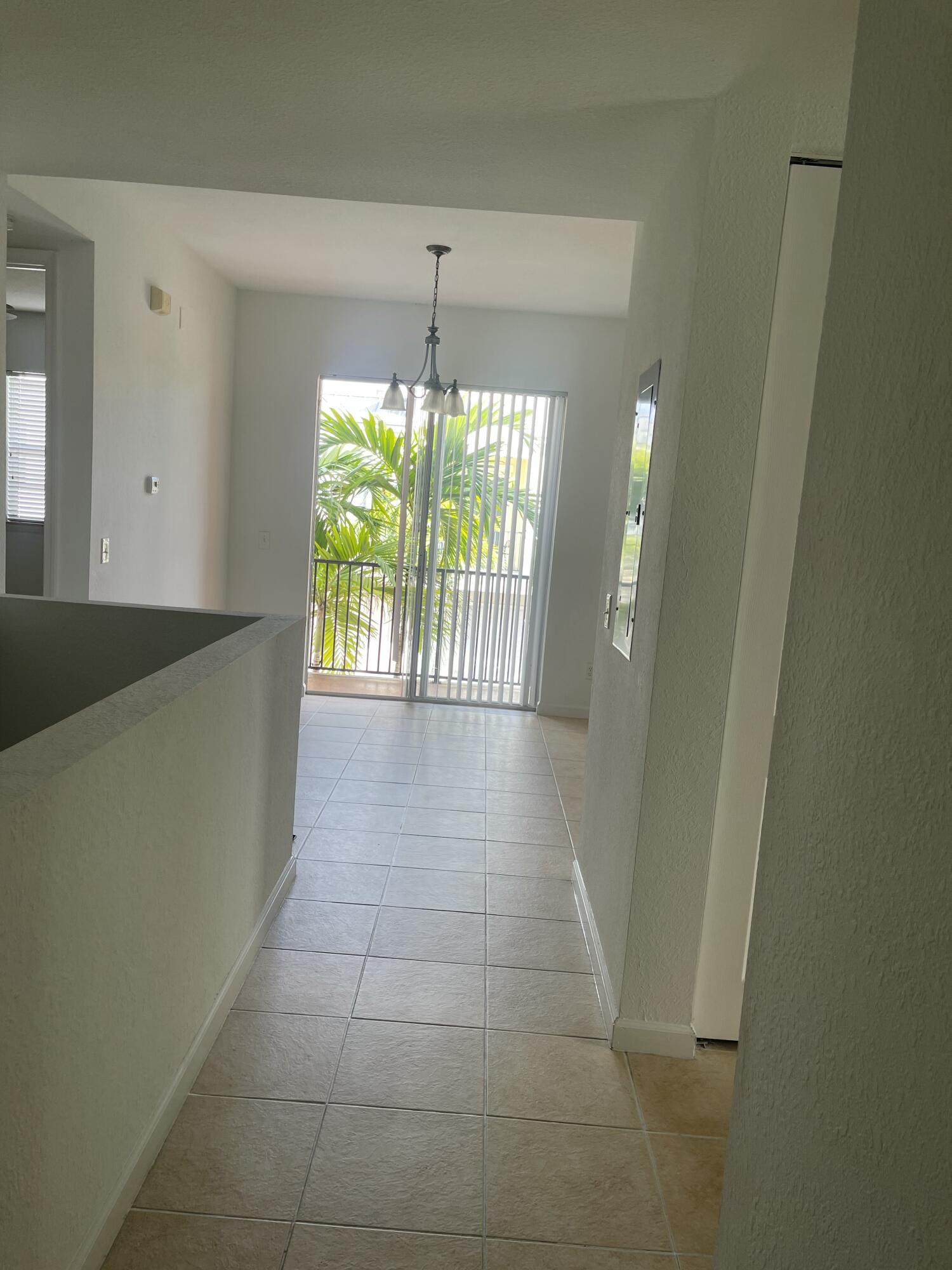 10440 Southwest Stephanie Way, Unit 211 Port St. Lucie, FL 34987 - Photo 11 of 13 a view of hallway with furniture and a chandelier