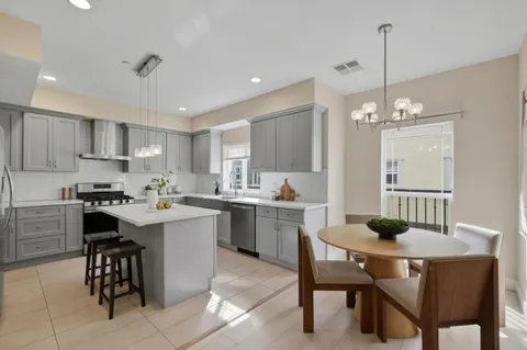 a kitchen with a dining table chairs sink and stove