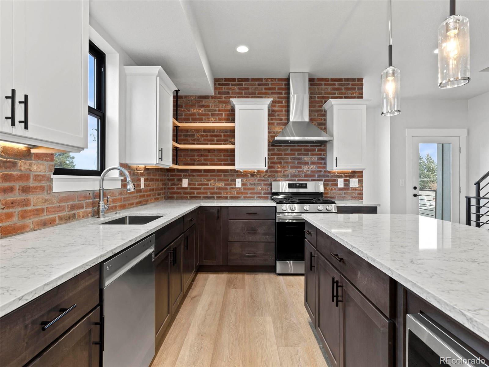 a kitchen with stainless steel appliances granite countertop a sink a stove and a wooden cabinets
