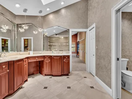 a bathroom with a granite countertop sink a mirror and shower