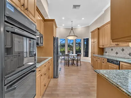 a kitchen with granite countertop a refrigerator and cabinets