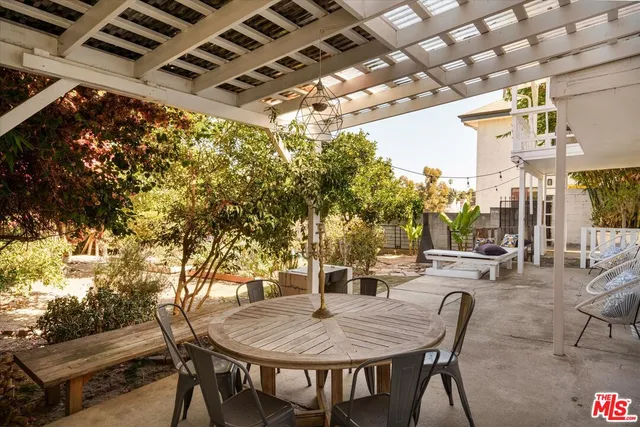 a view of a patio with table and chairs with wooden fence and plants