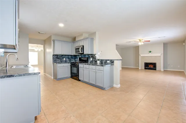 a kitchen with stainless steel appliances granite countertop a stove a sink and a refrigerator