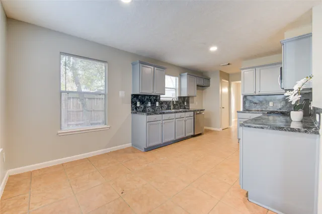 a view of an empty room with a fireplace and a window