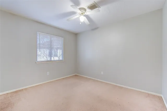 a view of an empty room with a ceiling fan