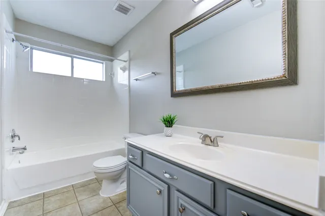 a view of an empty room with chandelier fan and fire place