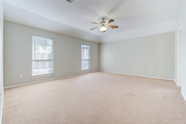 an empty room with a window and a ceiling fan