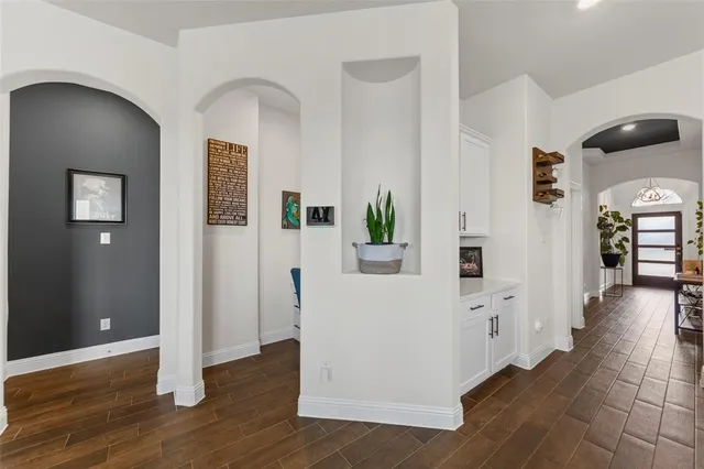 a view of a hallway with wooden floor and windows