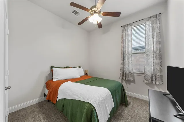 a bedroom with a bed tv and a window