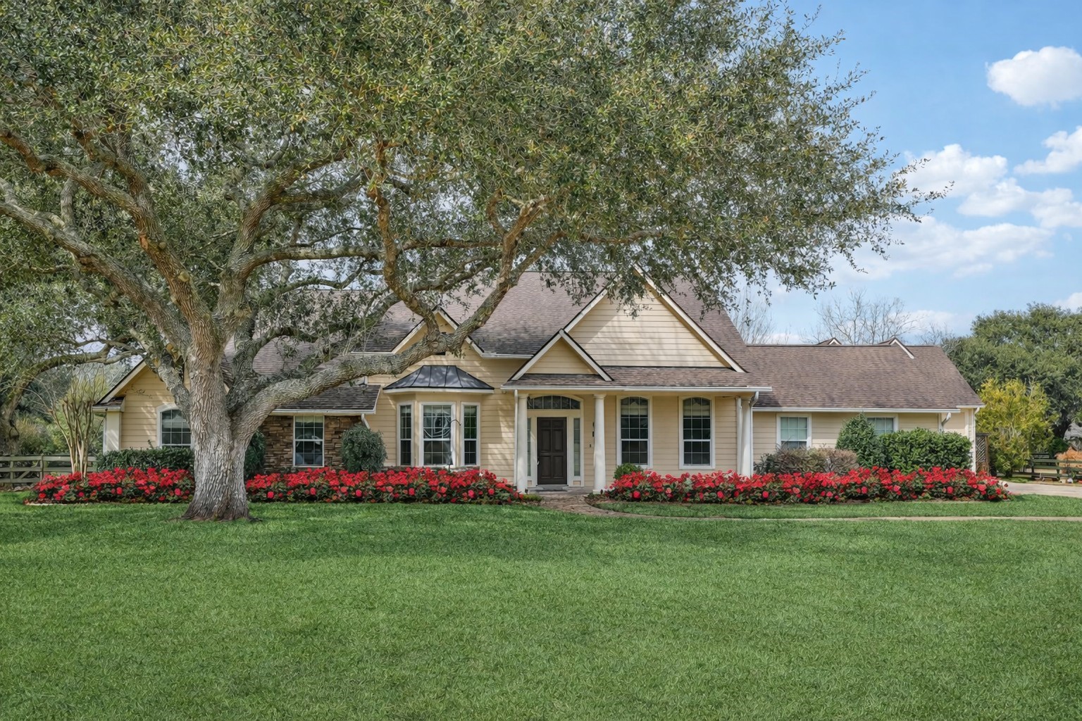 a front view of a house with a garden and trees