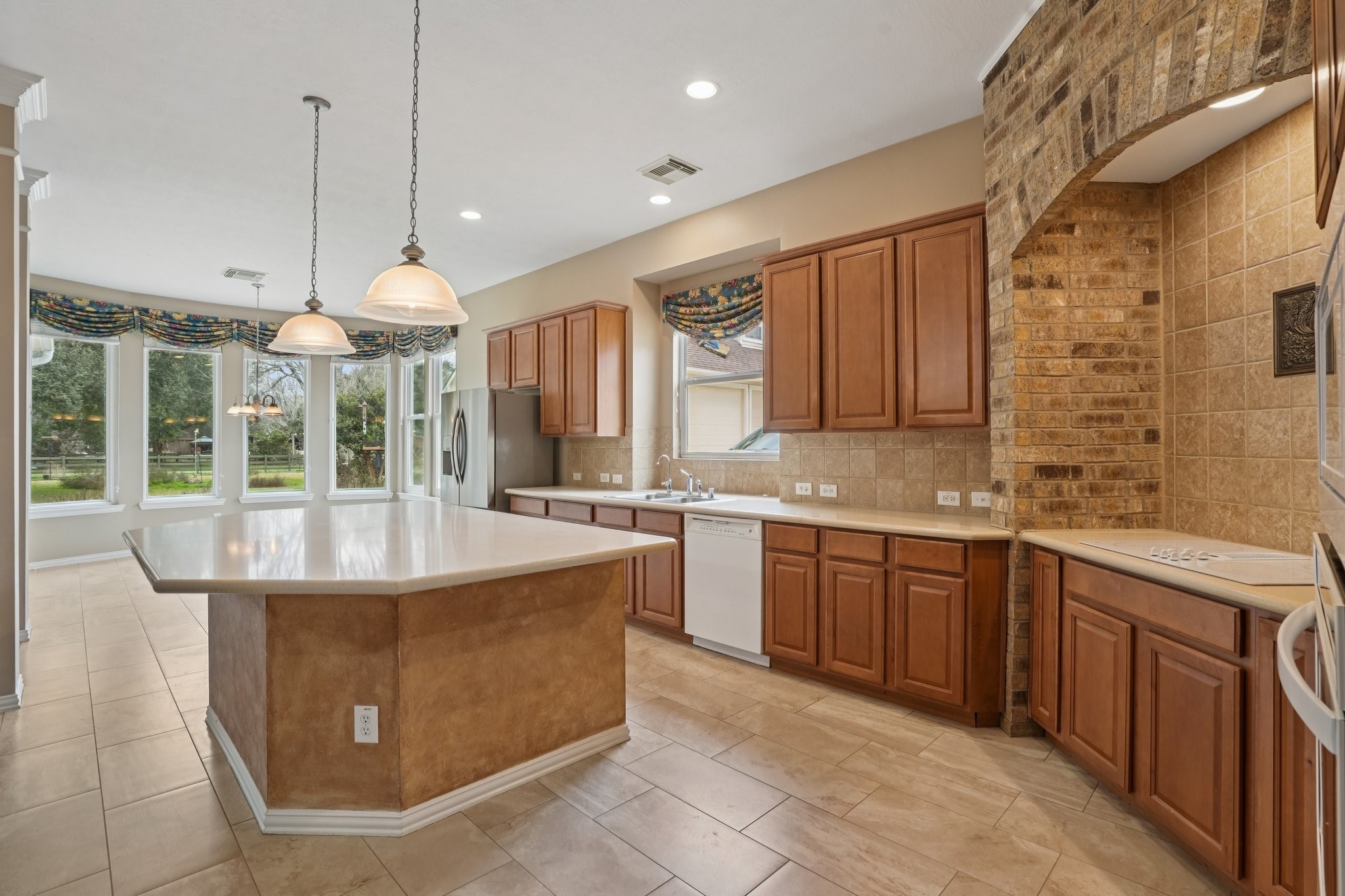 31810 Tree Farm Lane Fulshear, TX 77441 - Photo 2 of 48 a large kitchen with kitchen island a large counter top space a sink stainless steel appliances and cabinets