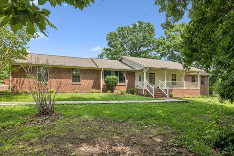 a view of a house with a yard and sitting area